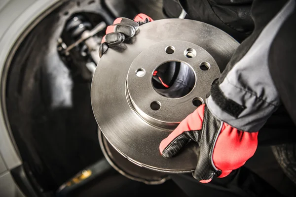 A mechanic holding a brake component